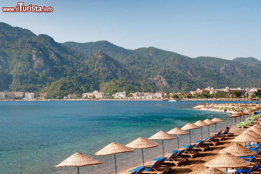 Immagine Un tratto di spiaggia sulla costa di Marmaris, Turchia. Sullo sfondo le montagne coperte di pinete.