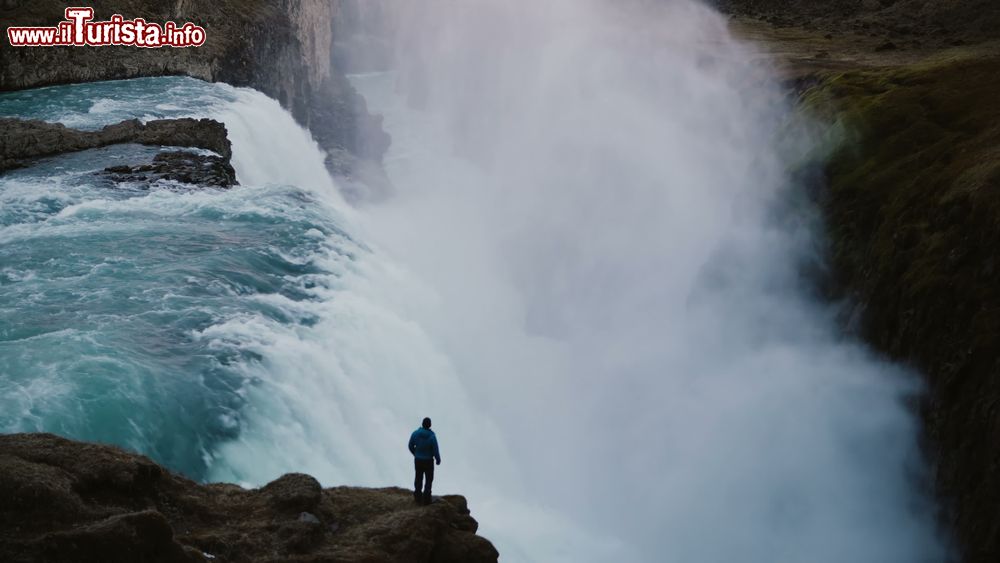 Immagine Un turista contempla la potenza della Cascata Gulfoss in Islanda