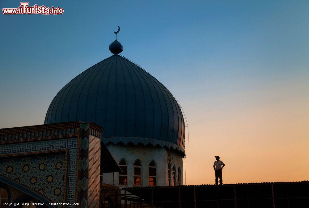 Immagine Un uomo osserva il tetto della moschea Haji Yakub a Dushanbe, Tagikistan, al calar del sole - © Yury Birukov / Shutterstock.com