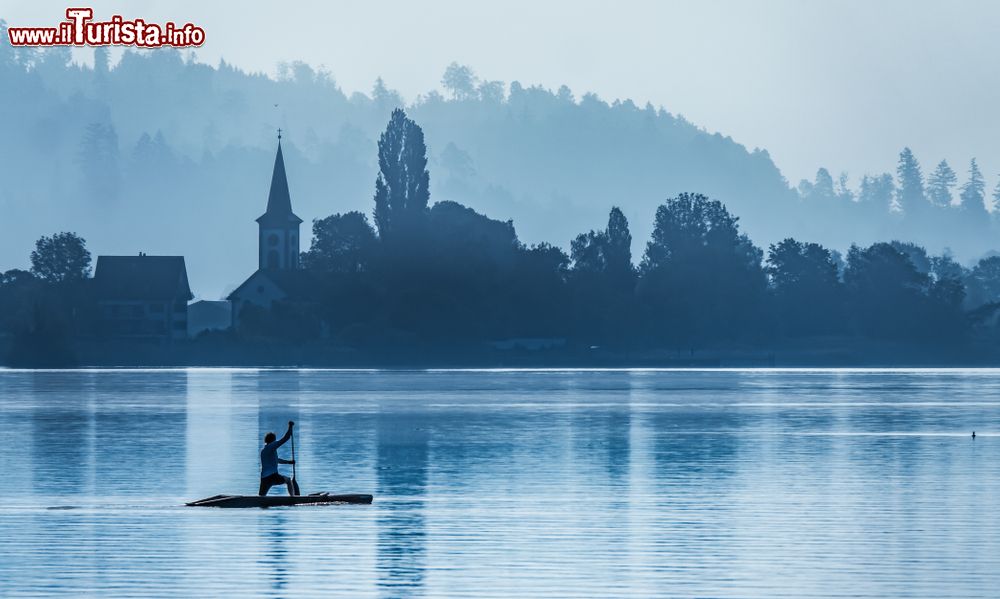 Immagine Un uomo pratica Sup (Stand up paddle) nei pressi del villaggio di Busskirch (Kirchdorf), a Rapperswil-Jona. Si tratta di una variante del surf in cui si sta in piedi su una tavola.