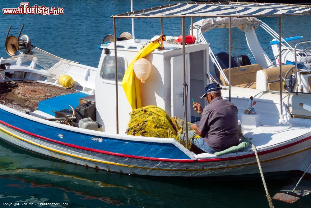 Immagine Un vecchio pescatore lavora alle sue reti nel porto di Lipsi, isola del Dodecaneso (Grecia) - © kokixx / Shutterstock.com