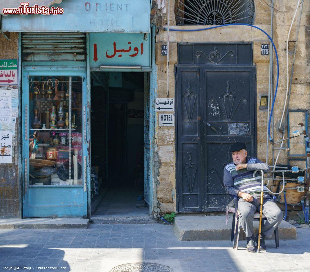 Immagine Un vecchio uomo seduto di fronte all'ingresso di un hotel a Sidone, Libano- © Catay / Shutterstock.com