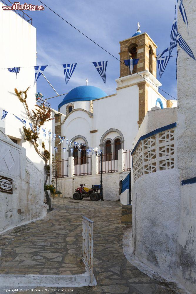 Immagine Un vicoletto nel villaggio di Lipsi, Dodecaneso, Grecia, addobbato a festa con bandiere greche - © Milan Gonda / Shutterstock.com