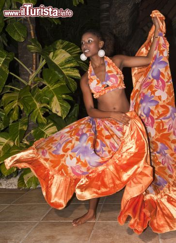 Immagine Una ballerina di sèga, la danza degli schiavi - una ballerina in abiti tipici balla la sèga, una danza affascinante le cui origini risalgono a quando Mauritius era una colonia francese e gli schiavi africani usavano ballarla davanti al fuoco. Questa danza è ndiffusa e amata ancora oggi e, per seguirla, le donne indossano delle ampie gonne colorate e con stampe a fiori.  - © bengy / Shutterstock.com