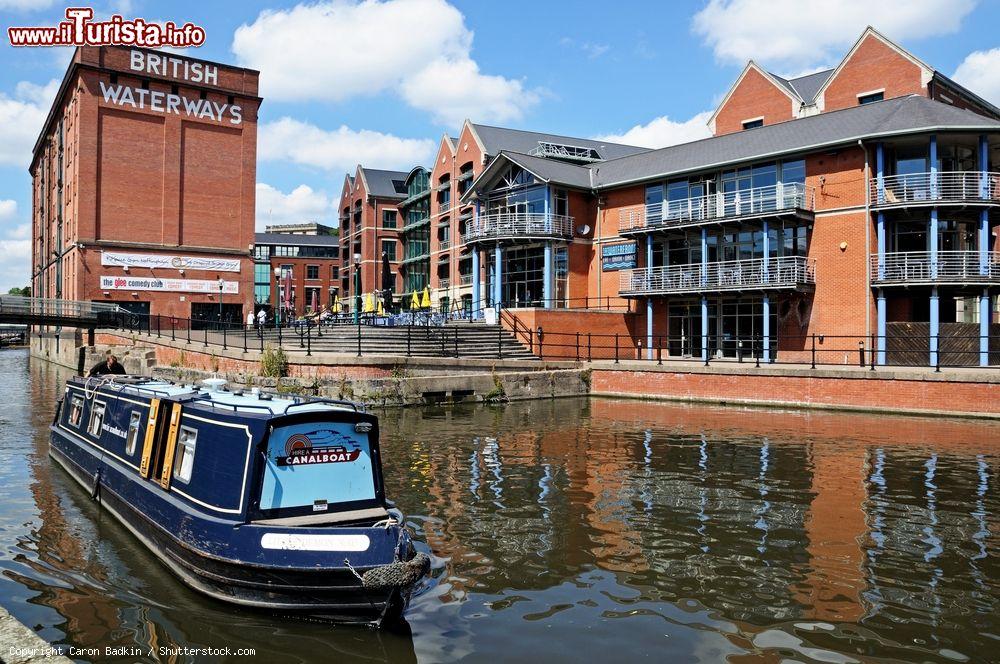 Immagine Una barca naviga lungo il Nottingham e Beeston Canal, Inghilterrra. Sullo sfondo, edifici affacciati sul molo cittadino - © Caron Badkin / Shutterstock.com