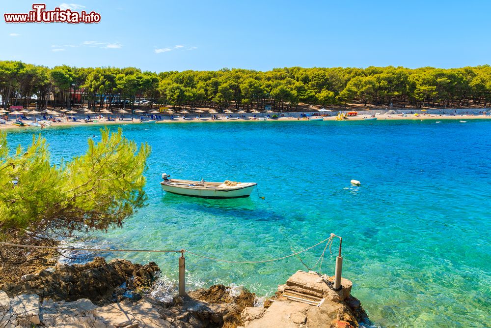 Immagine Una barchetta in legno nella splendida baia di Primosten, Dalmazia, Croazia. Questa località attrae i turisti per la sua interessante architettura ma anche per le spiagge lambite da acque azzurre e cristalline.