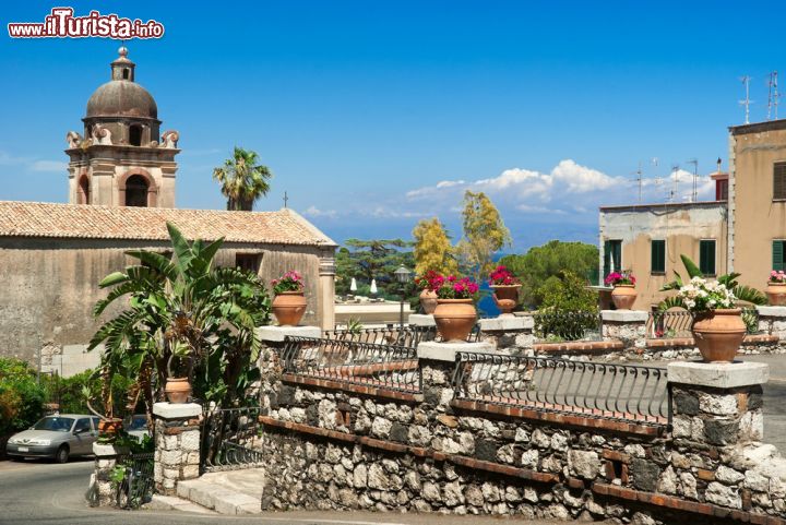 Immagine Una bella veduta di Taormina, la celebre città della Sicilia. Cielo azzurro, fiori e piante sono l'incantevole scenario naturale di questo angolo cittadino.