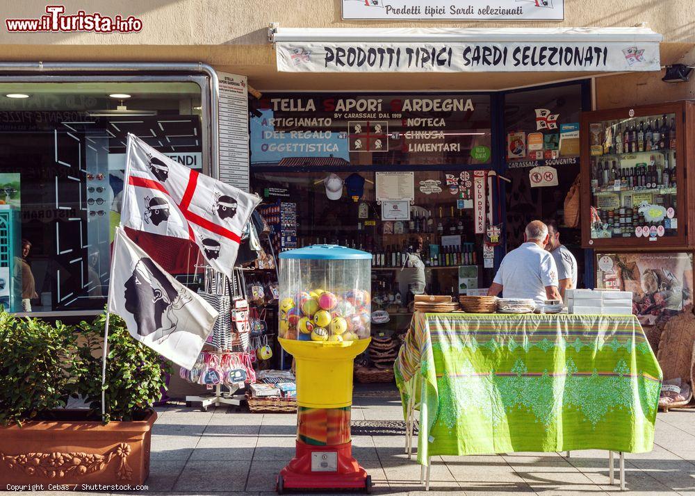 Immagine Una bottega di tipici prodotti gastronomici e souvenir a Olbia, Sardegna. In primo piano, su un lato, la bandiera dei quattro mori sventola al vento  - © Cebas / Shutterstock.com