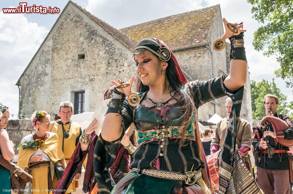 Immagine Una danzatrice con tradizionali costumi balla in strada a Provins, Francia. Il festival medievale si svolge nell'arco di un week end alla metà di giugno - © HUANG Zheng / Shutterstock.com