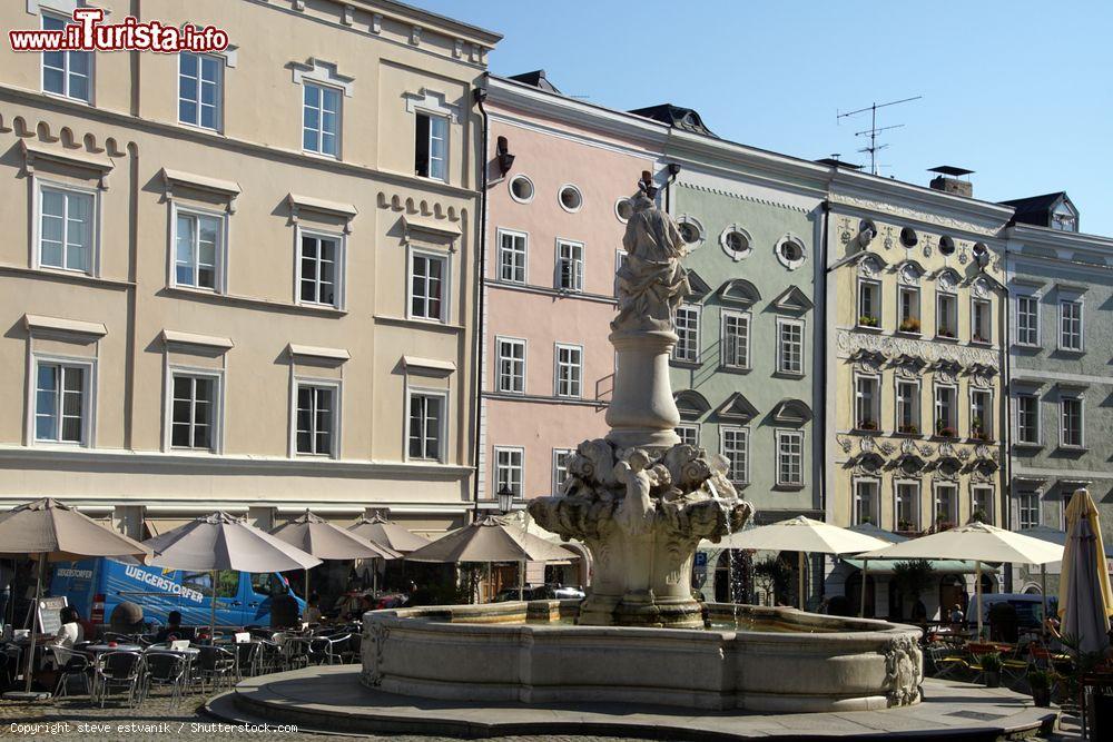 Immagine Una fontana nella piazza cittadina di Passau, Germania, con sullo sfondo eleganti palazzi dalla facciata pastello - © steve estvanik / Shutterstock.com