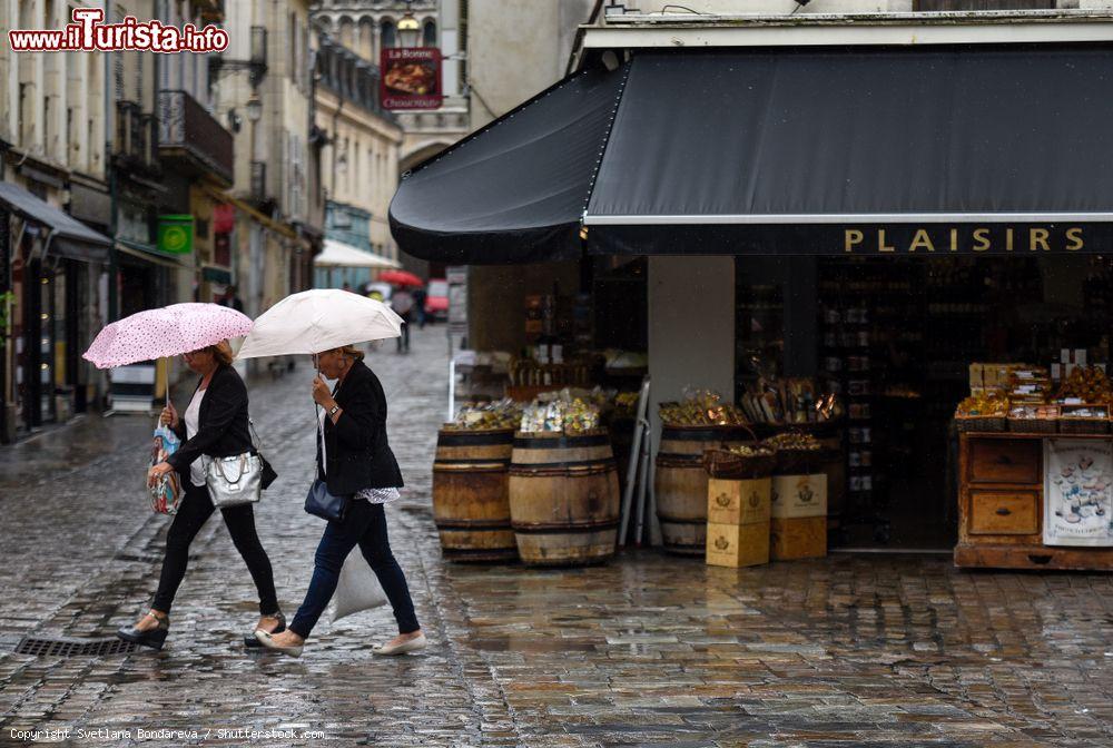 Immagine Una giornata di pioggia a Digione, Francia: due donne passeggiano con il loro ombrello per il centro cittadino nonostante le condizioni meteo avverse - © Svetlana Bondareva / Shutterstock.com