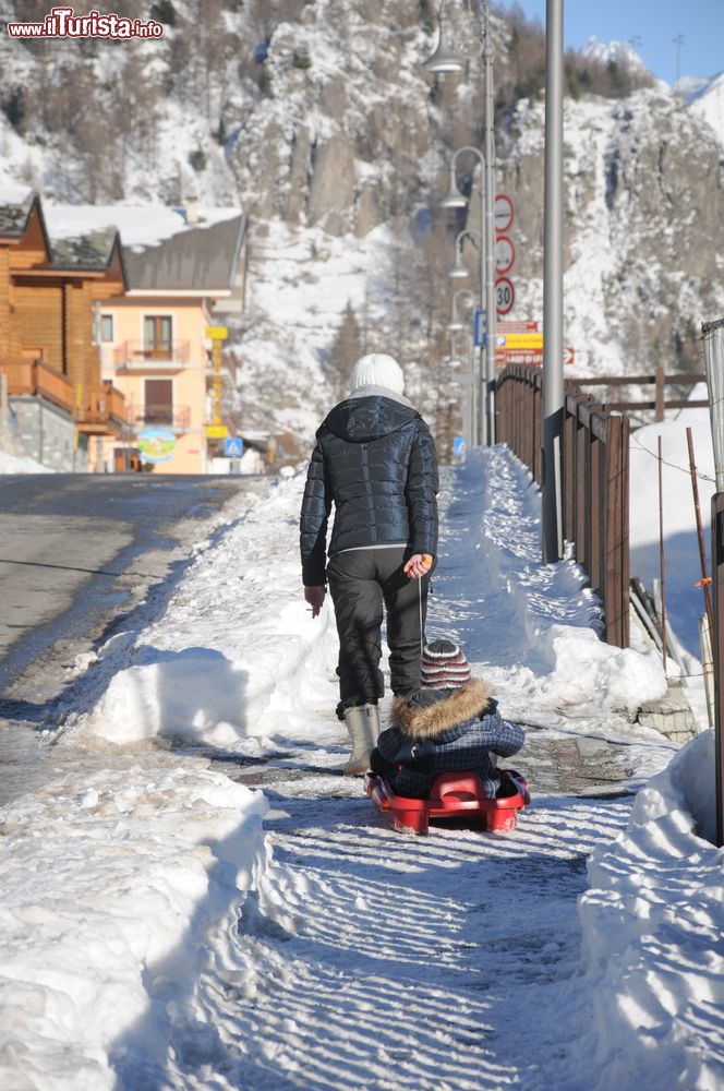 Immagine Una giovane mamma con il suo bimbo sullo slittino nelle strade di Valpelline, Valle d'Aosta.