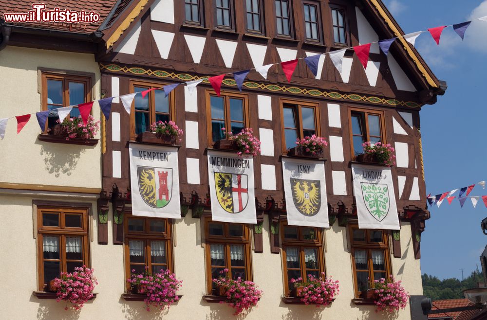 Immagine Una storica casa a graticcio con vecchie bandiere di Kempten, Memmingen, Isny e Lindau, Germania.