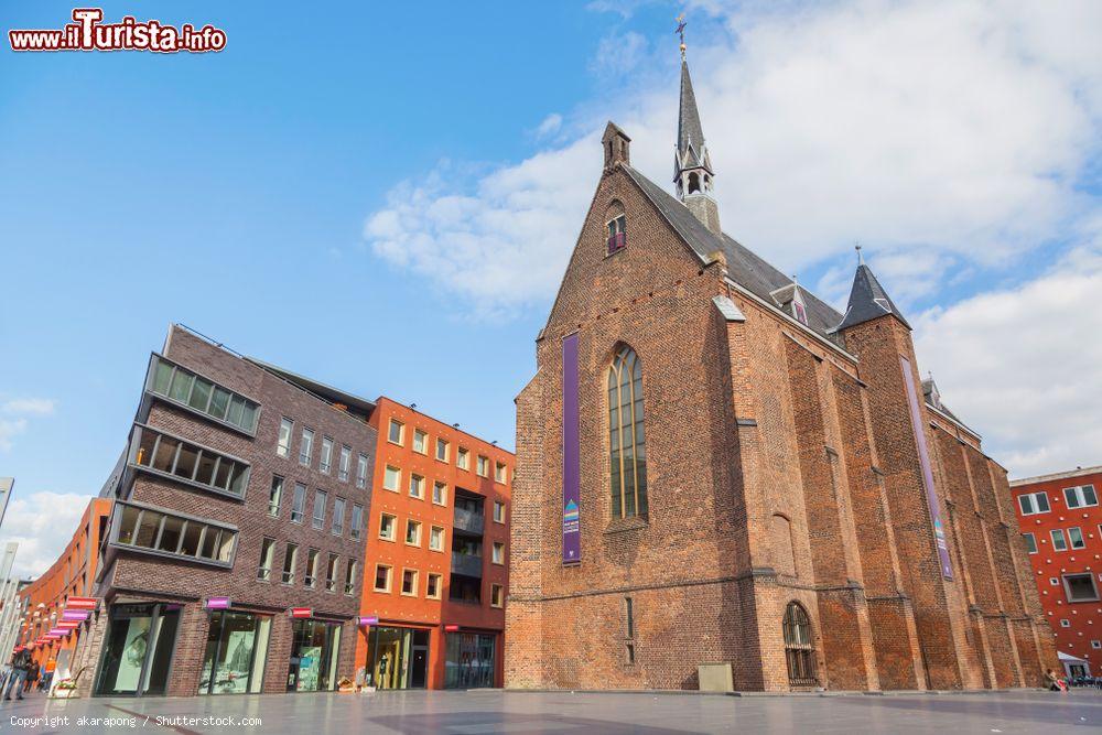 Immagine Una storica chiesa in mattoni nel centro di Nijmegen, Olanda. Su un lato, le vetrine dei negozi  - © akarapong / Shutterstock.com