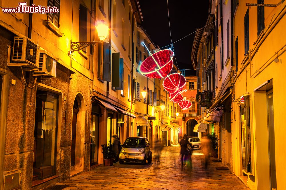 Immagine Una stretta stradina di Reggio Emilia, Emilia Romagna, fotografata di notte. A creare atmosfera, le decorazioni luminose a forma di ombrello.