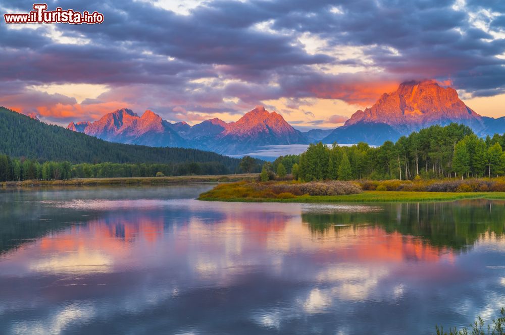 Immagine Una suggestiva alba al Grand Teton National Park in Wyoming, USA. I riflessi rossastri del cielo si riflettono nell'acqua del fiume Snake, il più lungo del parco.