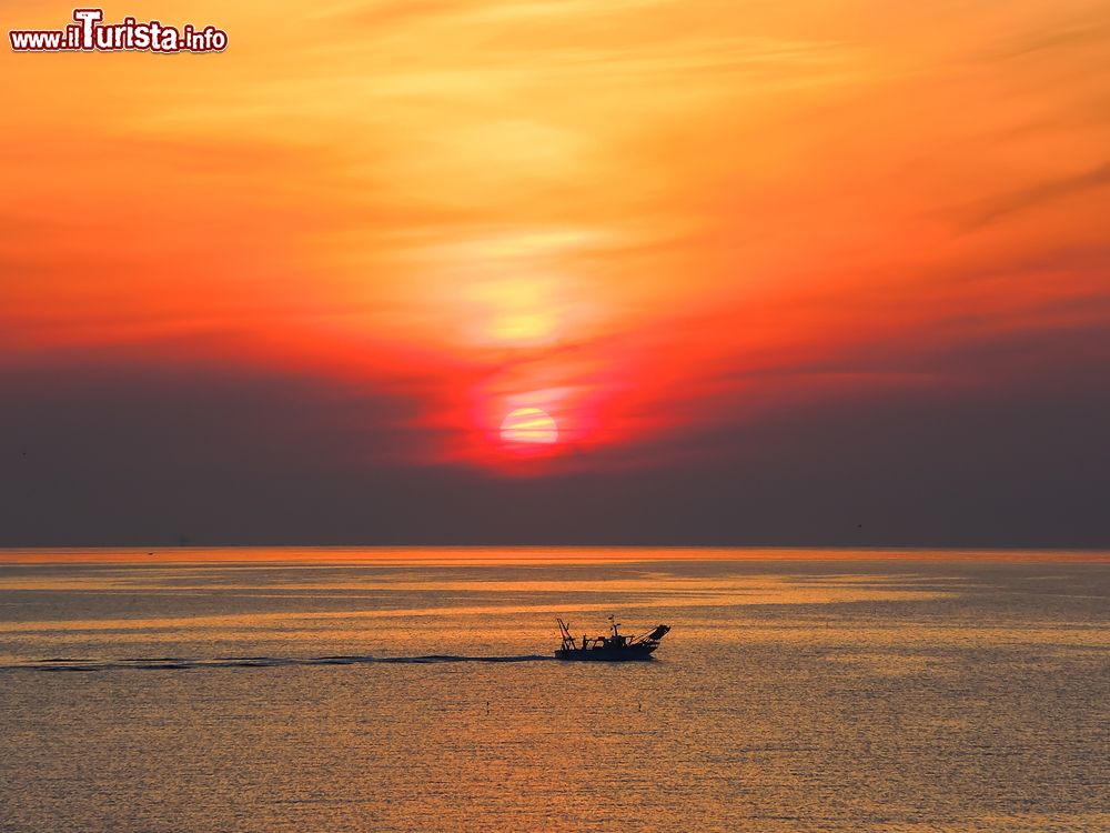 Immagine Una suggestiva alba sul Mar Adriatico a Cattolica, Emilia Romagna. Questa nota località balneare della riviera romagnola ha una ricca tradizione marinara. E' conosciuta anche con il nome di Regina dell'Adriatico.