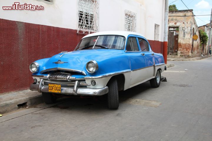 Immagine Un'automobile Plymouth a Camaguey, Cuba -  Una bella auto del marchio automobilistico statunitense Plymouth, appartenente a Chrysler dal 1928 e attivo sino al 2001, parcheggiata in una strada di Camaguey. Solo con le leggi più recenti i cubani hanno potuto commerciare in auto, motivo per cui i mezzi di trasporto sull'isola sono per la maggior parte di vecchia data © Tupungato / Shutterstock.com