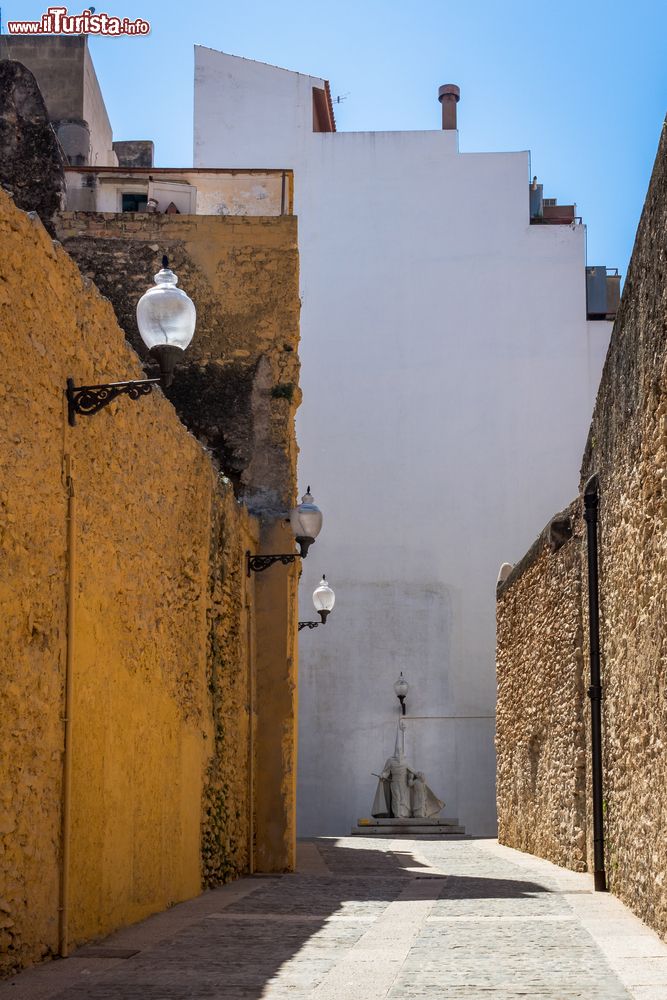 Immagine Una tipica viuzza della cittadina costiera di Vinaros, Spagna. Sullo sfondo, un'antica statua in marmo.