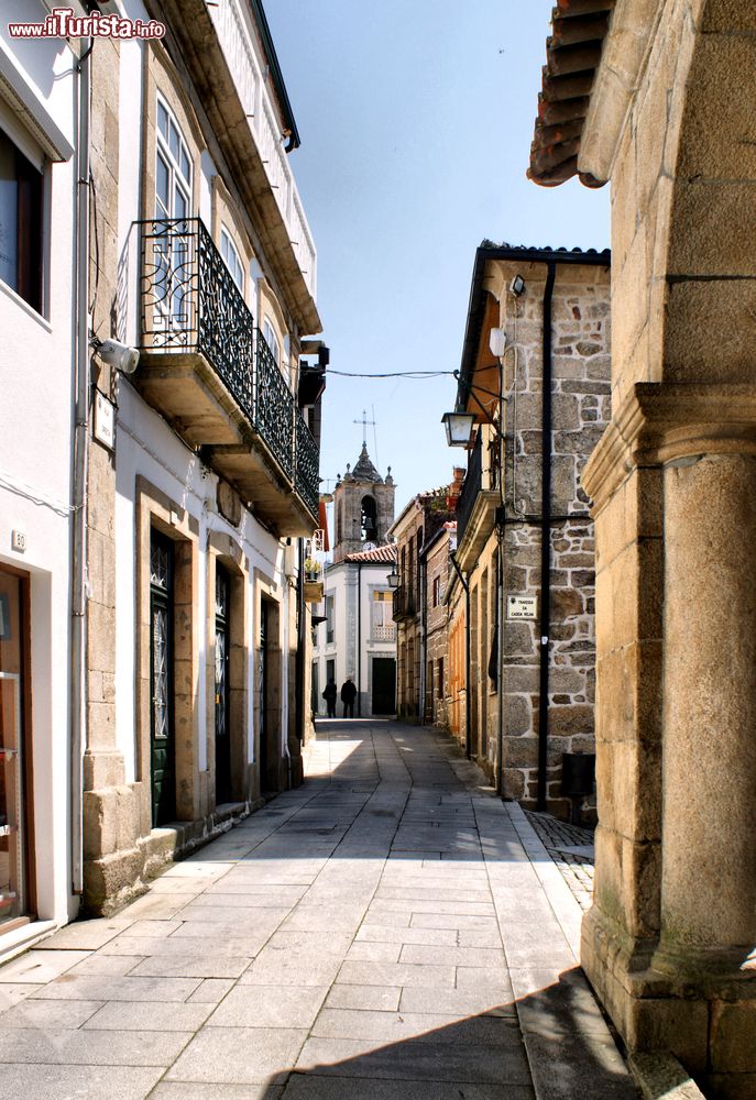 Immagine Una viuzza nel centro storico di Melgaco, Portogallo. Sullo sfondo, un'antica chiesa del paese.