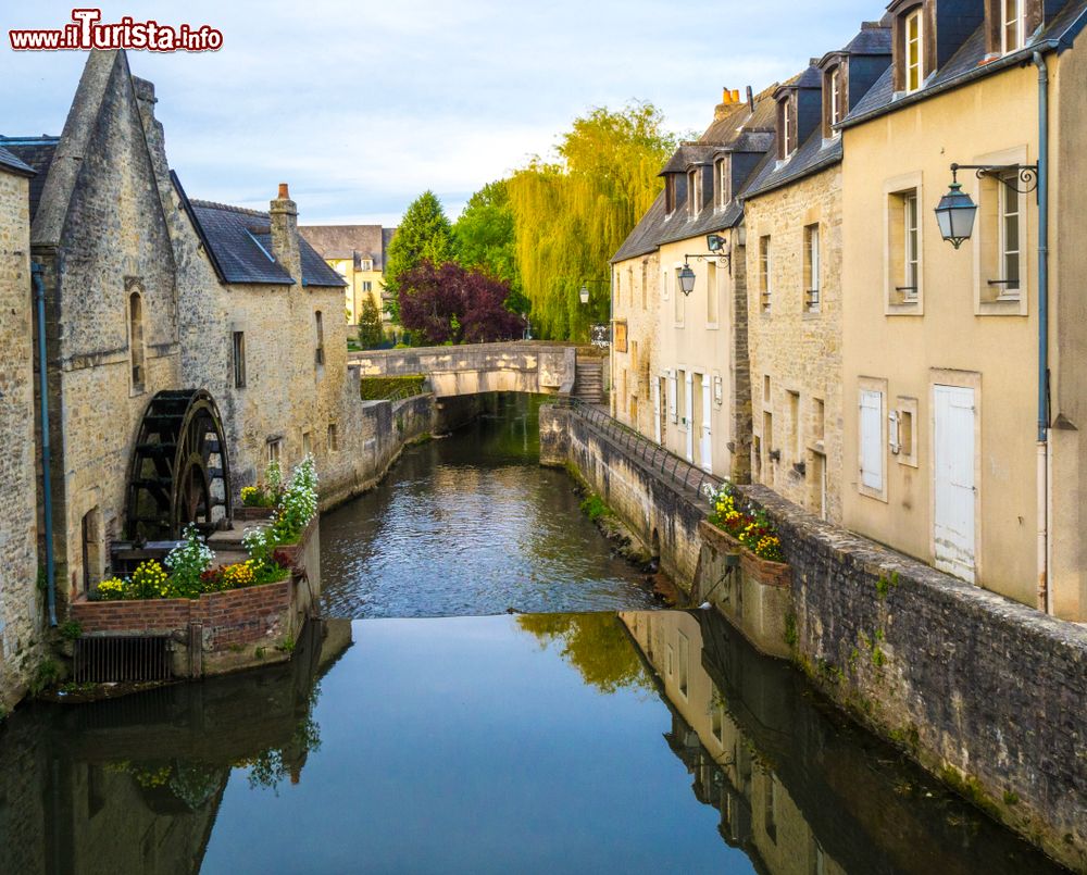 Immagine Uno scorcio del centro storico di Bayeux (Francia) con il ponte che attraversa il fiume. La fama di questa località del Calvados deriva dal celebre arazzo medievale dichiarato patrimonio dell'umanità.