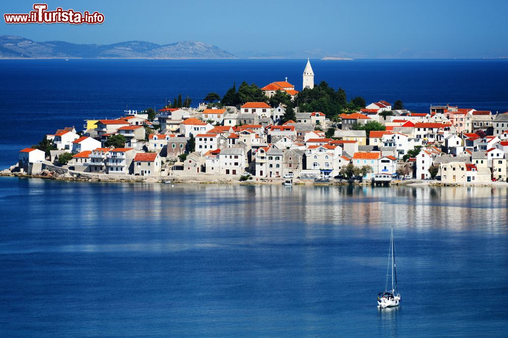 Immagine Uno scorcio della penisola dalmata di Primosten, Croazia. E' una destinazione turistica unica al mondo riconosciuta per la sua suggestiva architettura, i prodotti legati all'agricoltura come vino e olio oltre che per le sue spiagge lambite da acque trasparenti e cristalline.