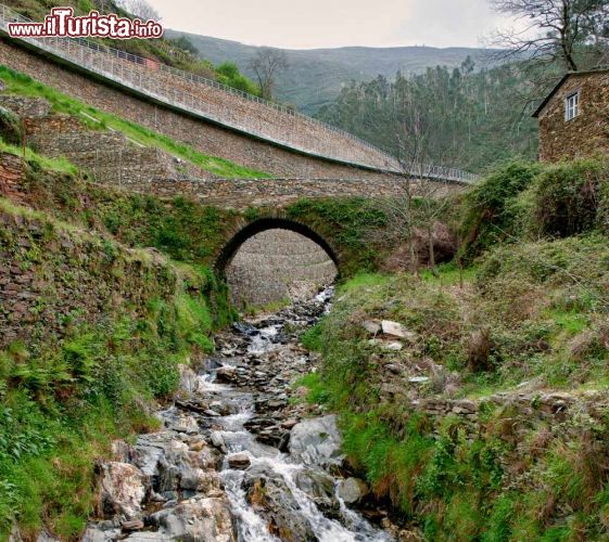 Immagine Vecchio ponte a Piodao, Portogallo - Uno stretto ponticello costruito in pietra attraversa un ruscello nel villaggio portoghese di Piodao: gli scorsi panoramici offerti dalla natura rendono questa località ancora più affascinante © homydesign / Shutterstock.com