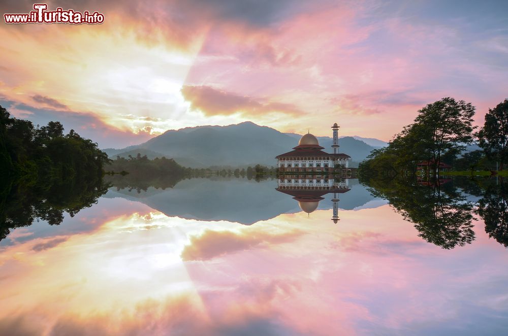 Immagine Veduta della moschea di Darul Quran al tramonto, Selangor, con i riflessi sull'acqua del lago.