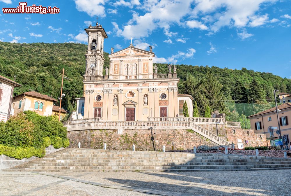 Immagine Veduta della parrocchia di Sant'Ambrogio a Porto Ceresio, Varese, Lombardia. Costruita nel 1722, si presenta con una bella facciata decorata da statue e sculture. Il campanile risale invece al 1911.