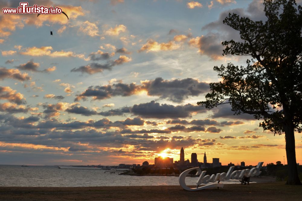 Immagine Veduta mattutina di Cleveland, Ohio, dal parco Edgewater: sullo sfondo, il lago Erie, la skyline della città e una persona con parapendio.