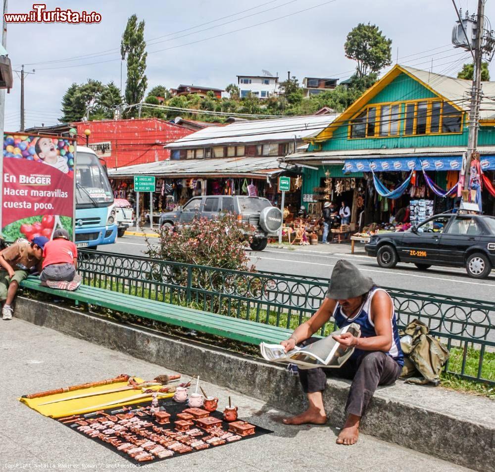 Immagine Un venditore di souvenir legge il giornale in attesa di clienti lungo una strada di Puerto Montt, Cile - © Natalia Ramirez Roman / Shutterstock.com