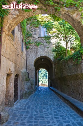 Immagine Una via del borgo laziale di Civita di Bagnoregio, Viterbo. Passeggiando fra gli stretti vicoli di questa frazione si possono ammirare interessanti scorci architettonici e suggestivi paesaggi sulla Valle dei Calanchi - © Mi.Ti. / Shutterstock.com