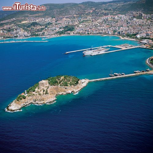 Immagine Baia di Kusadasi e Mar Egeo dall'alto, Turchia - Guvercinada, importante base militare, nel 1834 venne sottoposta ad un'opera di ricostruzione da parte dei veneziani e degli ottomani che realizzarono la famosa fortezza: il nome della città attualmente in uso , "Kusadasi", che significa isola degli uccelli, deriva proprio dalla fortezza. In questa immagine scattata dall'alto, le acque limpide dell'Egeo circondano l'isolotto collegato alla costa da una sottile striscia di terra © jokerpro / Shutterstock.com