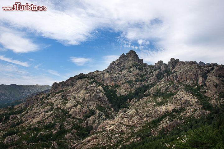 Immagine Le Cime di Bavella, Corsica - Cime di Bavella, o Guglie di Bavella, è un massiccio situato nei pressi di Solenzara, nella Corsica sud-orientale, famoso per le sue guglie di granito rosa, per la vasta foresta che si estende ai suoi piedi e per il passaggio del fiume Solenzara, che insieme al colle, crea un paesaggio naturale davvero mozzafiato. 