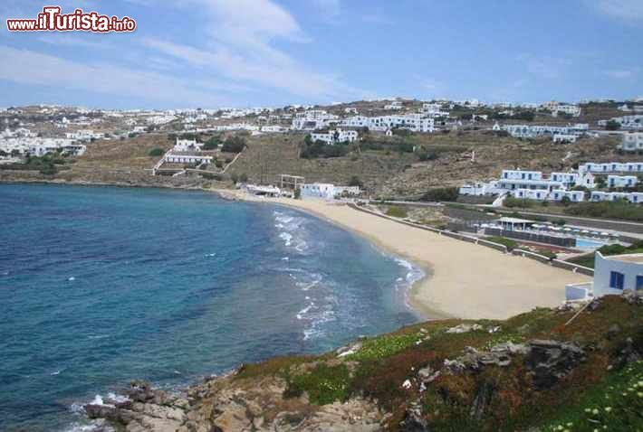 Immagine Megali Ammos, la spiaggia Chora a Mykonos, Grecia. Sorge ad appena 2 chilometri dall città di Mykonos e Little Venice. Il nome Megali Ammos significa "grande sabbia" perchè prima che venisse costruita la strada, la sabbia si estendeva fino sotto la collina.