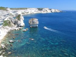 Al largo di Bonifacio, nel Sud della Corsica, il mare è una tavolozza di blu, turchesi e verdi intensi. In questa zona la costa è rocciosa, con alte falesie calcaree che luccicano ...