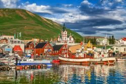 Il porticciolo di Husavik (Islanda) con le case dai tradizionali tetti a punta. Sullo sfondo la Húsavíkurkirkja, la chiesetta costruita nel 1907.


