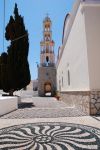 Il cortile con mosaici in ciottoli e la torre campanaria della chiesa di Agios Nikolas, isola di Chalki (Grecia). La torre campanaria è la più alta nelle isole del Dodecaneso.

 ...