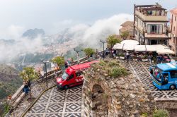 La piazza di Castelmola con i bus turistici, Sicilia. Costruita nel 1954, piazza Sant'Antonio è il belvedere sulla sottostante Taormina, in questa immagine fotografata sotto un cielo ...