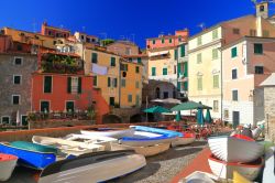 Le case tradizionali si affacciano sul porto di Tellaro dove sono ormeggiate le barche di legno, La Spezia, Italia.

