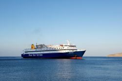 Una nave da crociera in arrivo sull'isola di Tilos, Grecia. Il porto principale è Livadia, a sudest di Megalo Horio, la località più turistica di questo angolo di arcipelago ...