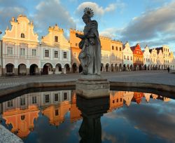 Panorama serale della piazza principale di Telc con gli edifici che si rispecchiano nella fontana pubblica con la statua di Santa Margherita, Repubblica Ceca.




