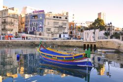 Le acque calme del porto St Julian's: a colorare la scena una barca tipica da pescatore, come se ne vedono molte sull'isola di Malta - © Arseniy Krasnevsky / Shutterstock.com 