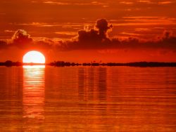 Un tramonto mozzafiato dalle tonalità rosse sulle acque dell'oceano a Abaco, Bahamas.



