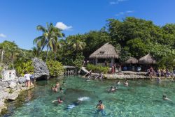 Turisti nuotano nel parco ecologico di Xcaret, Messico - © posztos / Shutterstock.com