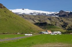 Un suggestivo paesaggio naturale con il Eyjafjallajokull innevato sullo sfondo, Islanda. Ricoperto da una calotta di ghiaccio, il vulcano raggiunge i 1.666 metri di altezza.
