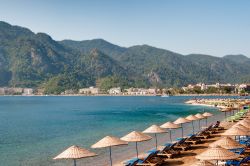 Un tratto di spiaggia sulla costa di Marmaris, Turchia. Sullo sfondo le montagne coperte di pinete.

