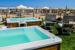 Una spiaggia di Riccione, Emilia Romagna, con sdraio, ombrelloni e jacuzzi - © s74 / Shutterstock.com