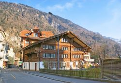 La via centrale di Interlaken con un vecchio chalet e le montagne sullo sfondo, Svizzera - © eFesenko / Shutterstock.com