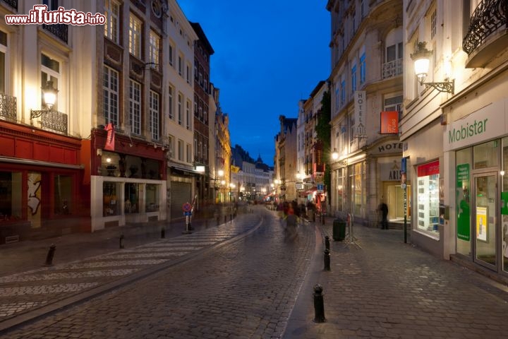 Immagine La Rue Du Marche-Aux-Herbes. Fa parte del complesso di stradine caratterstiche del centro di Bruxelles, chiamato Ilot Sacrè, e famoso per i suoi negozi e ristoranti - © SergiyN / Shutterstock.com